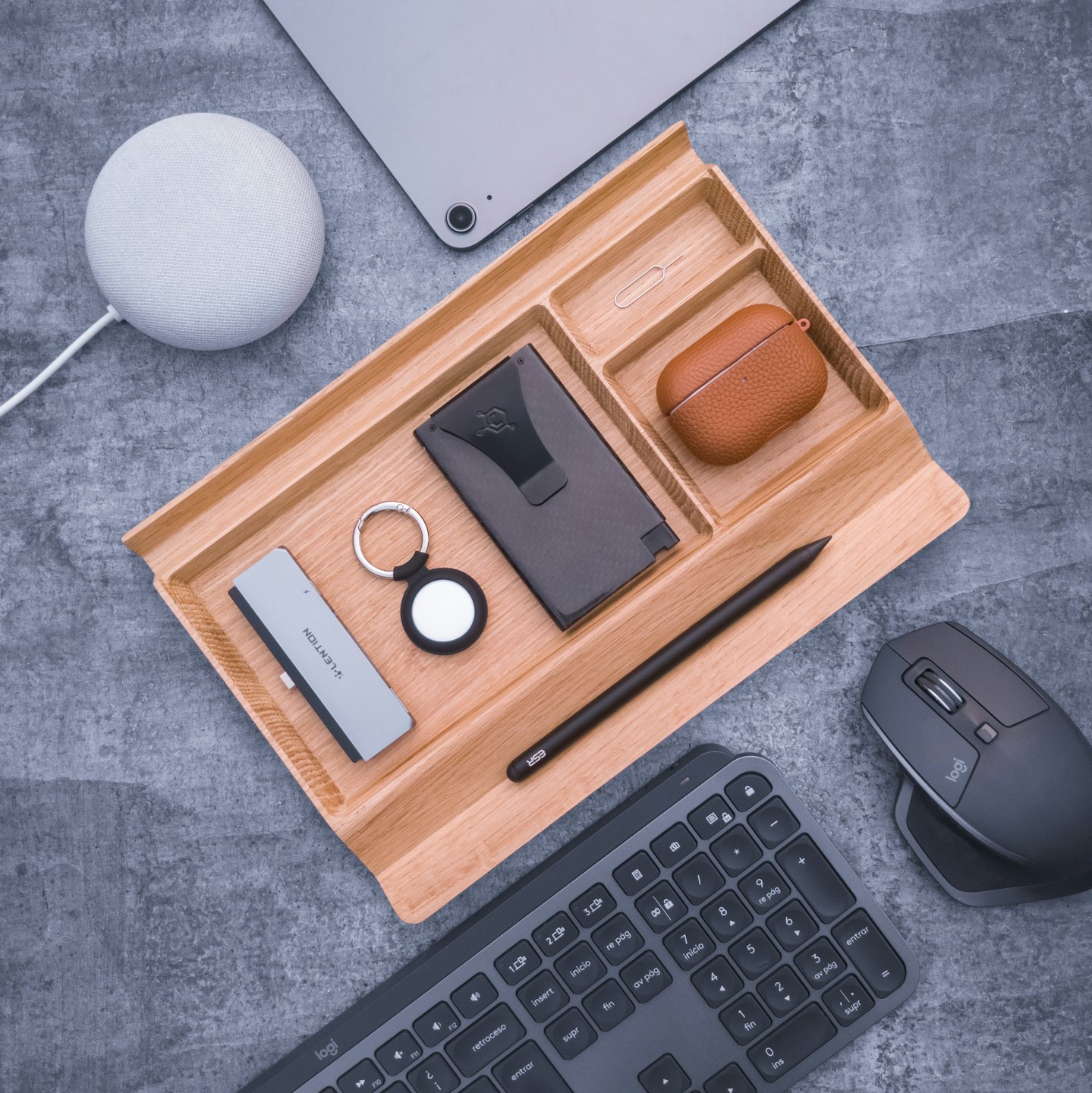 Modern tech gadgets neatly arranged in a wooden desk organizer.