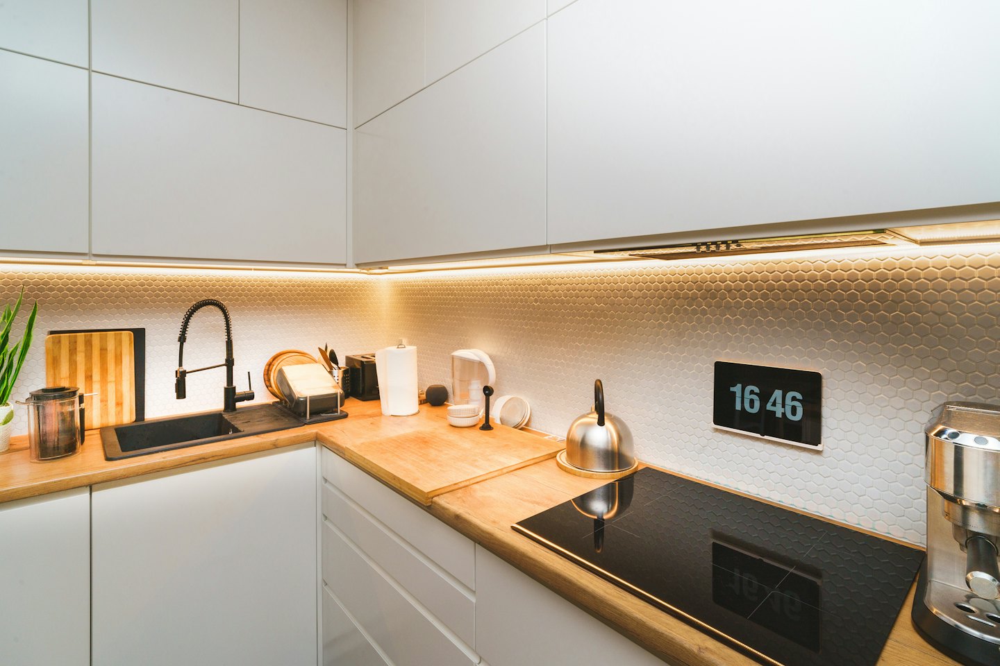 Modern kitchen with white cabinets and wooden countertops.